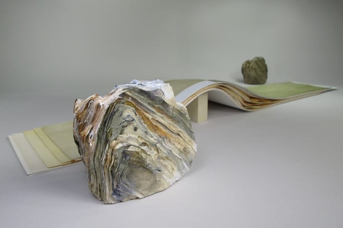 Artwork by Carmine Iannaccone, colorful rock with layers of paper wave in back