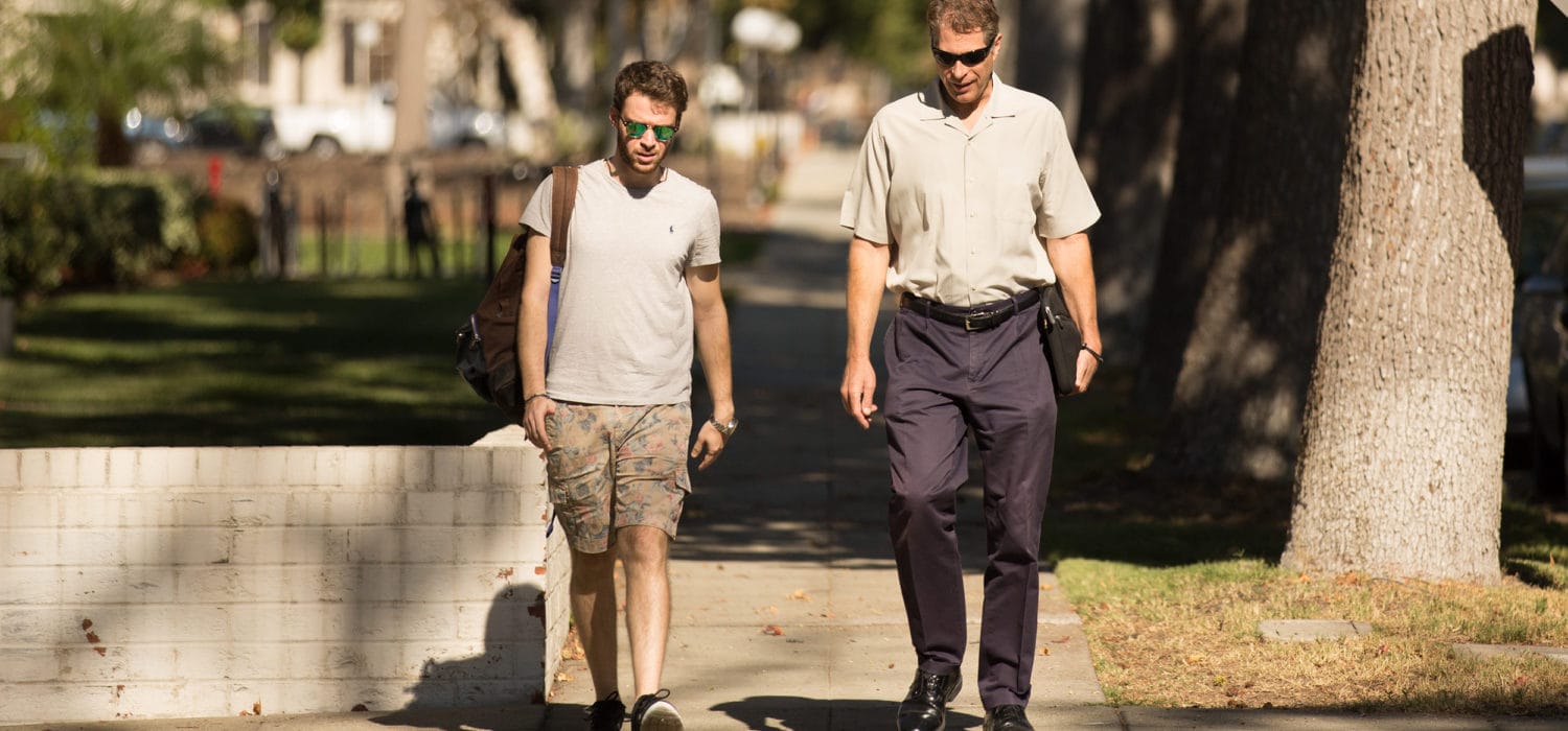 Two men walking outside through campus