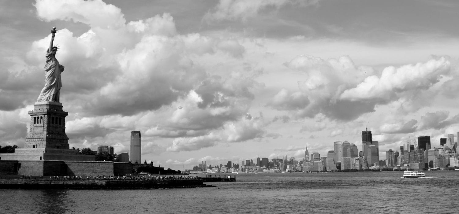 black and white photo of New York Harbor with statue of liberty
