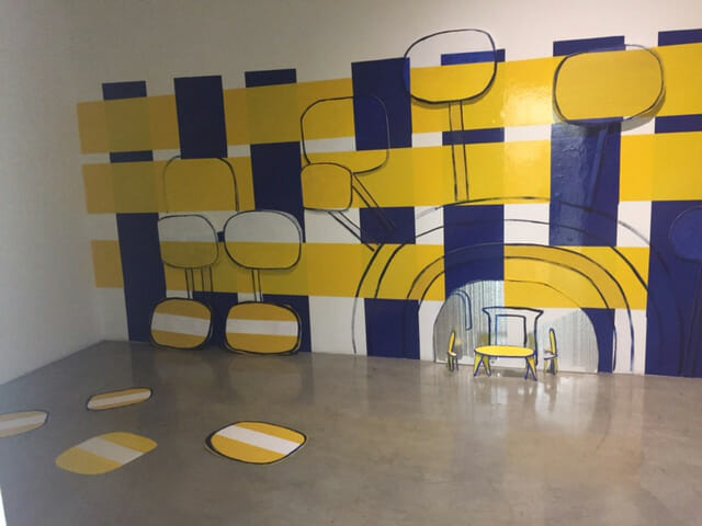 Student artwork by Adrienne Cole, yellow and blue shapes in installation room
