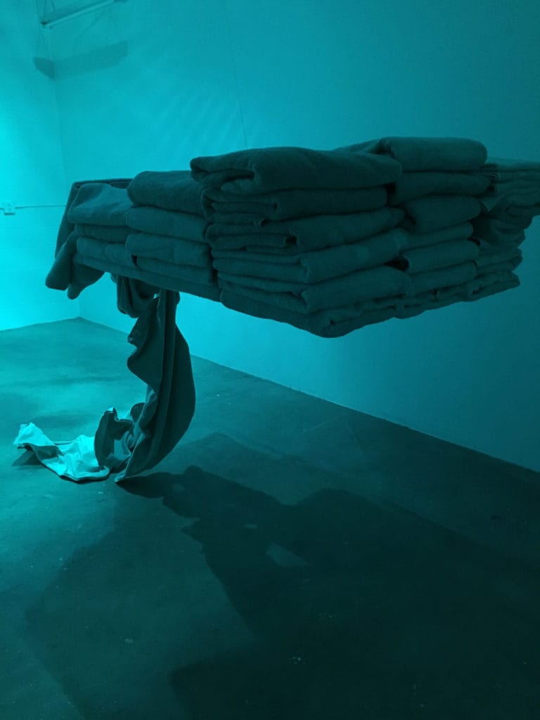 Student artwork by Rafaella Suarez, towels folded in air, with a few falling down