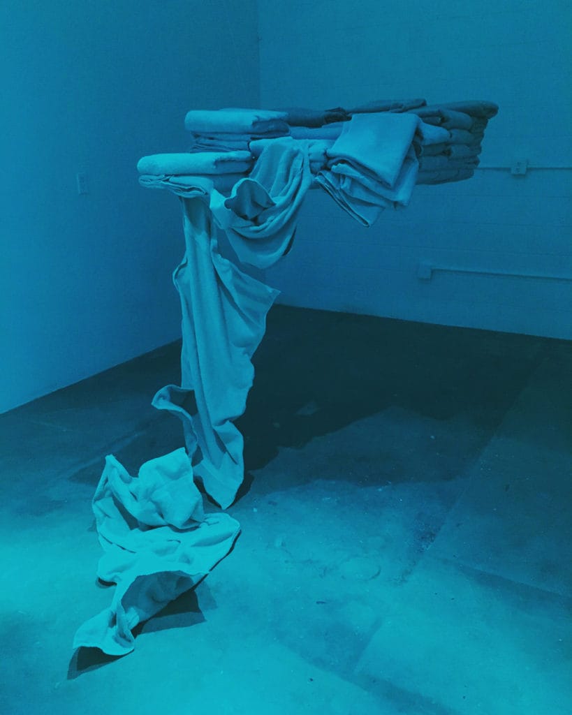 Student artwork by Rafaella Suarez, towels floating in air mostly folded and a few falling down
