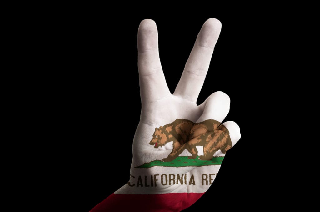 Photo of hand with peace gesture in colored California state flag.