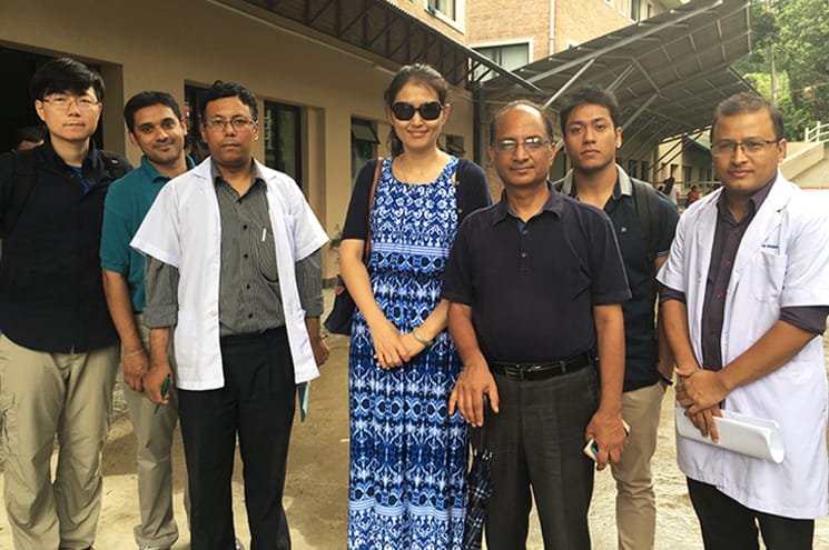 Professor Yan Li standing with people in Nepal