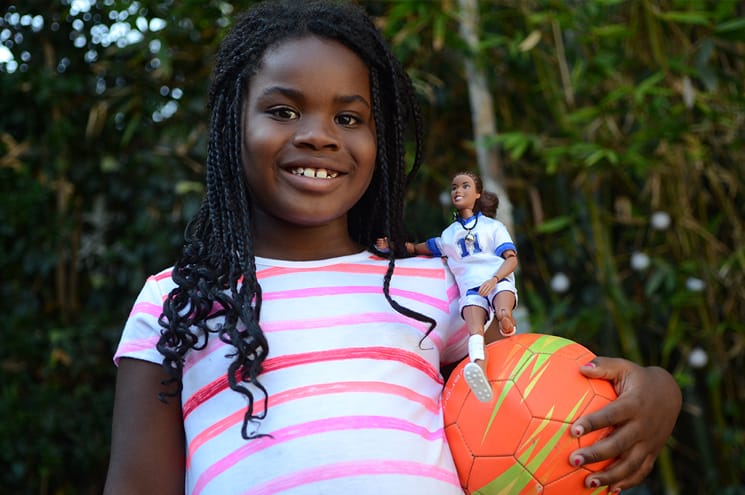 Young girl holding Get Real Girl doll and soccer ball