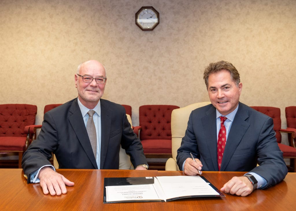 WesternU President Daniel R. Wilson, MD, PhD, left and CGU President Len Jessup, PhD, sign a memorandum of understanding (MOU) Tuesday, June 4, 2019