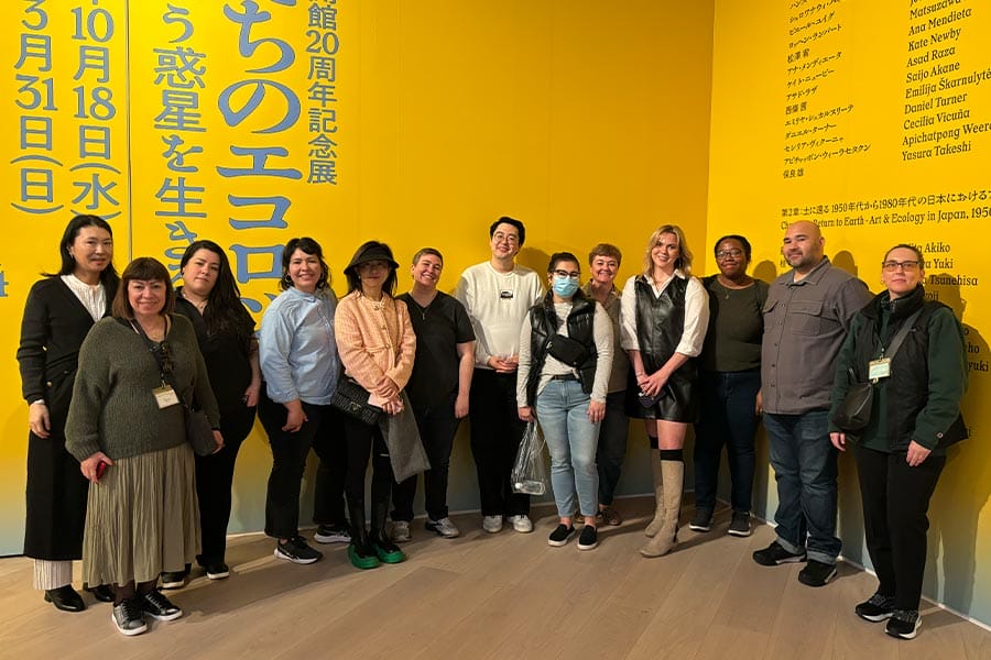 Group of students from the Drucker School of Management standing next to a yellow wall