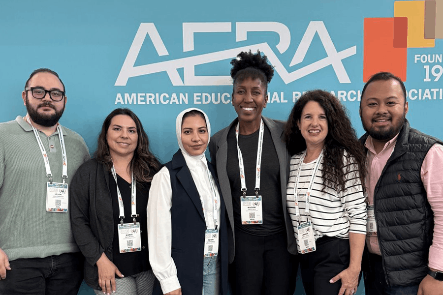 A group of PhD students stand together for a photo at the American Education Research Association Conference